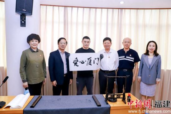 残障人士代表现场书写毛笔字“爱心厦门”。