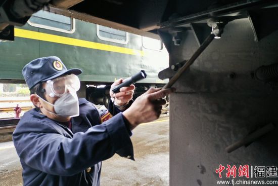 2.发电车乘务员在列车整备库内，敲击检查车下电池箱固定螺栓，保证紧固安全。王玉星 摄