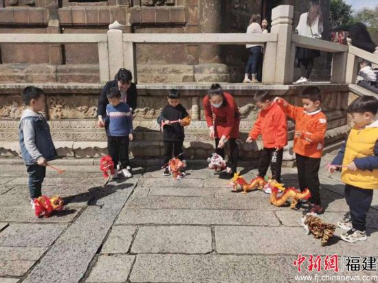 仁寿塔下，孩子们自编自演了一出提线木偶戏。