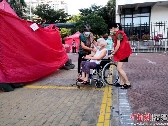 志愿者帮助行动不便的老人。陈向辉 摄