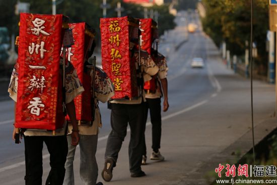 泉台青年接力背着妈祖神像徒步。