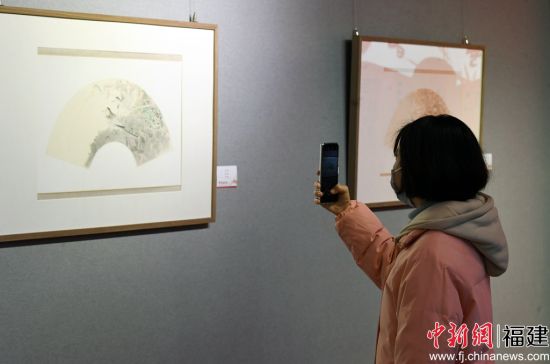 一名女青年用手机拍摄参展作品。记者 刘可耕 摄