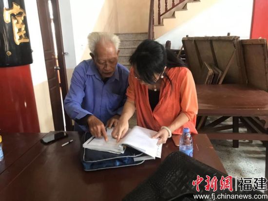 图为王平跟平潭五福堂族人查找五福文化资料 图为王平跟平潭五福堂族人查找五福文化资料