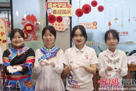 图为少数民族学生包月饼共度中秋佳节。