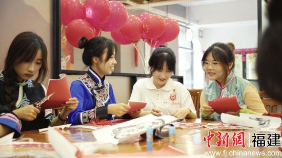 图为少数民族学生包月饼共度中秋佳节。