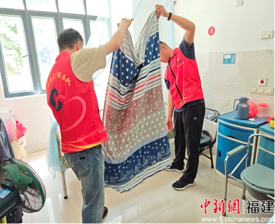 图为退役军人高伟彬等在房间内帮忙整理被褥。谢丹供图。